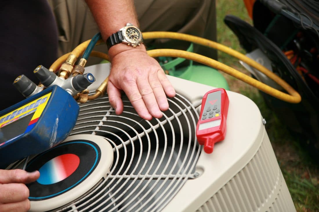 Technician servicing a commercial HVAC rooftop unit